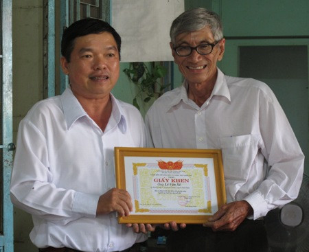 Ông Trần Hoàng Nhân - giám đốc Sở GD-ĐT Long An trao bằng khen tới ông Nguyễn Văn Biểu (ảnh: Dân Trí)