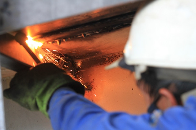 Một công nhân hàn lại "vết thương" cho tàu ở một góc xa. Một công nhân hàn lại "vết thương" cho tàu ở một góc xa.