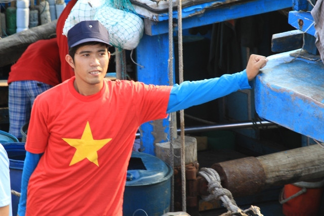 Một ngư dân trẻ không khỏi dấu được cảm xúc khi mang trên mình chiếc áo in hình lá cờ Tổ quốc. Anh đứng nép ở một góc tàu. "Đây là một chuyến đi biển đặc biệt...", ngư dân trẻ này tâm sự. Một ngư dân trẻ không khỏi dấu được cảm xúc khi mang trên mình chiếc áo in hình lá cờ Tổ quốc. Anh đứng nép ở một góc tàu. "Đây là một chuyến đi biển đặc biệt...", ngư dân trẻ này tâm sự.