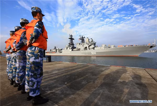 Lính Trung Quốc đứng đón chiến hạm Nga ghé thăm trụ sở Hạm đội Nam Hải ở Trạm Giang, sau khi tập trận chung trên Biển Đông năm ngoái, ảnh: Tân Hoa Xã.