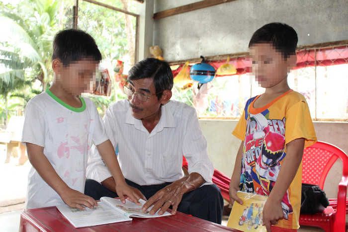 Ông Huỳnh Hà Thắng, hiệu trưởng Trường Tiểu học thị trấn Lịch Hội Thượng A kiểm tra khả năng đọc của K. và T. - Ảnh: K.T. / Báo Tuổi trẻ Online. Ông Huỳnh Hà Thắng, hiệu trưởng Trường Tiểu học thị trấn Lịch Hội Thượng A kiểm tra khả năng đọc của K. và T. - Ảnh: K.T. / Báo Tuổi trẻ Online.