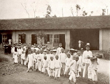 Trẻ em trong một trung tâm nuôi dưỡng ở Hà Nội đang đi vào nhà ăn.