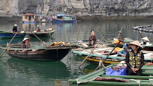 Những người phụ nữ đang chờ khách đi đò ở làng nổi thuộc Vịnh Hạ Long. Đây là điểm đón khách từ thuyền lớn sang thuyền nhỏ muốn vào tham quan quần thể hang động nhỏ được UNESCO xếp hạng di sản văn hóa thế giới.