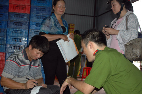 Tuy nhiên, xưởng sản xuất này vẫn cho ra đời hàng loạt chai nước tăng lực không đảm bảo chất lượng. Về vấn đề này, Giám đốc Cty TNHH Hưng Phát, ông Nguyễn Trọng Tiến giải thích : “Chúng tôi mới sản xuất được 1 tháng, bán ra thị trường chưa đáng bao nhiêu”. Ảnh: Ông Tiến, Giám đốc Cty (ngoài cùng bên trái) làm việc với cơ quan công an.