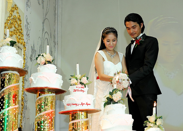 Quách Ngọc Ngoan cầm tay Lê Phương, thắp từng ngọn nến trên các chiếc bánh kem trắng muốt.