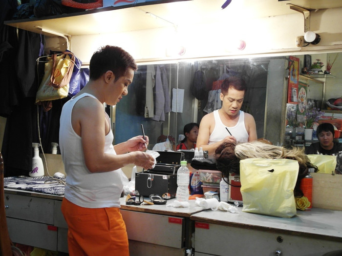 Minh Nhí, người thầy của nhiều thế hệ diễn viên, đang đứng trước bàn trang điểm.