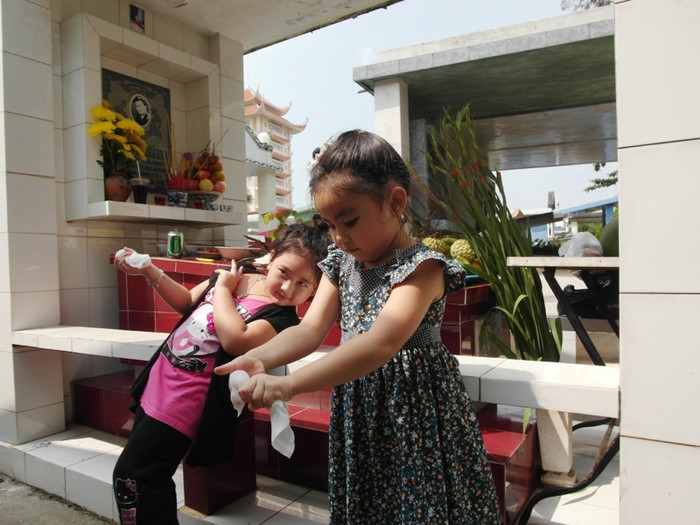 Bí Ngô tạo dáng bên mộ người bạn thân của bố, trong khi Hạt Dẻ nghịch với chiếc khăn giấy. Bí Ngô tạo dáng bên mộ người bạn thân của bố, trong khi Hạt Dẻ nghịch với chiếc khăn giấy.