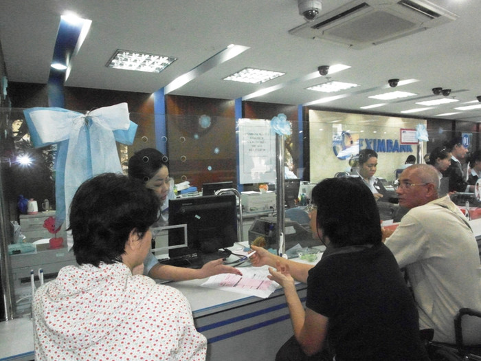 Một nhân viên đang giải thích lãi suất gửi tiền dài hạn tại ngân hàng. Một nhân viên đang giải thích lãi suất gửi tiền dài hạn tại ngân hàng.