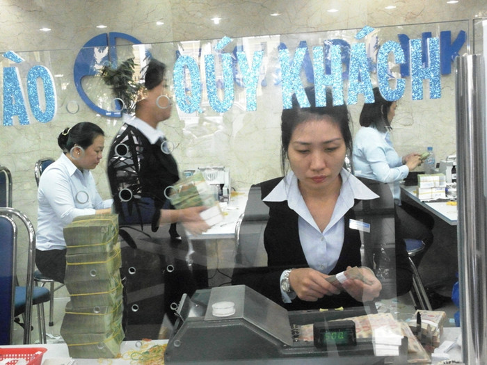 Cô nhân viên đang cần mẫn ngồi kiểm soát số tiền khách gửi chiều nay bằng máy đếm. Cô nhân viên đang cần mẫn ngồi kiểm soát số tiền khách gửi chiều nay bằng máy đếm.