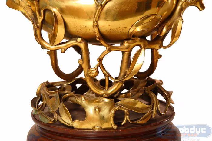 Hai quả đào nằm chồng lên nhau, trên một chiếc đế vững chắc, được cách điệu thành một gốc đào cổ thụ. Hai quả đào nằm chồng lên nhau, trên một chiếc đế vững chắc, được cách điệu thành một gốc đào cổ thụ.