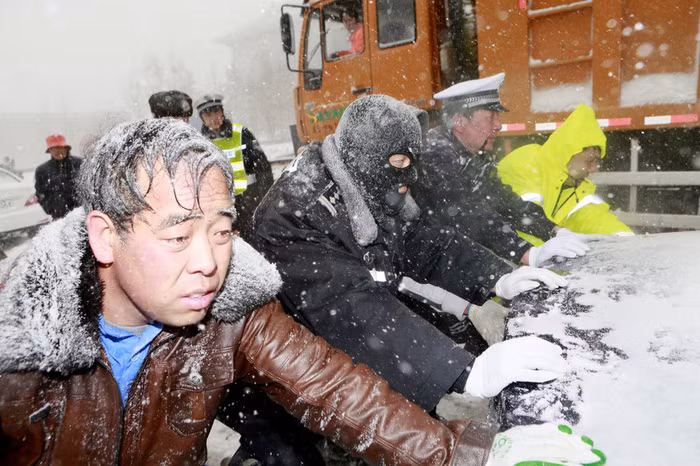 Các lực lượng vũ trang và chủ xe cùng đẩy 1 chiếc ô tô bị tuyết dày chặn đứng Các lực lượng vũ trang và chủ xe cùng đẩy 1 chiếc ô tô bị tuyết dày chặn đứng