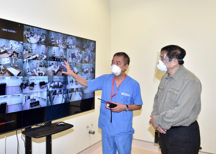 Bác sĩ Nguyễn Lân Hiếu, Giám đốc Bệnh viện Đại học Y Hà Nội phụ trách Bệnh viện dã chiến điều trị COVID-19 tại Bệnh viện quốc tế Becamex giới thiệu với Thủ tướng hoạt động điều trị chung của Bệnh viện dã chiến qua hệ thống giám sát trung tâm. Ảnh: VGP/Nhật Bắc