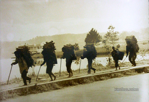 Một đoàn người Lạch đang gùi củi đi qua hồ Xuân Hương ra phía trung tâm thành phố bán cho người Kinh. Một đoàn người Lạch đang gùi củi đi qua hồ Xuân Hương ra phía trung tâm thành phố bán cho người Kinh.