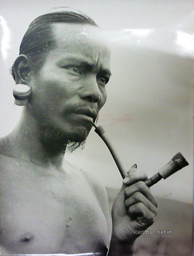 Chàng trai người Lạch đeo khuyên tai, cầm tẩu hút thuốc trông dáng vóc uy nghi như một tù trưởng được miêu tả trong các sử thi Tây Nguyên. Chàng trai người Lạch đeo khuyên tai, cầm tẩu hút thuốc trông dáng vóc uy nghi như một tù trưởng được miêu tả trong các sử thi Tây Nguyên.