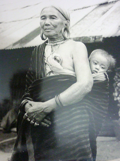 Một phụ nữ địu con (cháu) trên lưng được cụ Phỉ chụp tại khu vực giáp ranh giữa TP Đà Lạt và huyện Lạc Dương ngày nay. Một phụ nữ địu con (cháu) trên lưng được cụ Phỉ chụp tại khu vực giáp ranh giữa TP Đà Lạt và huyện Lạc Dương ngày nay.