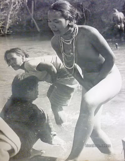 Thời điểm này, những chàng trai, cô gái người Lạch coi chuyện không mặc quần áo là điều bình thường, họ thả sức ngắm nhìn cơ thể gợi cảm của nhau, trai gái yêu nhau thường ra rừng tâm sự, nhưng tuyệt nhiên không có chuyện “ăn cơm trước kẻng”. Ảnh: Một thiếu nữ tỏ ra e ngại trước ống kính máy ảnh, vội vã bỏ chạy khỏi dòng suối đang tắm.