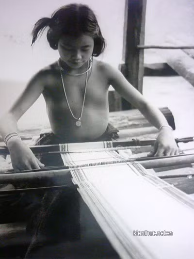 Vào mỗi buổi chiều, trên đầu nguồn con suối Lạch dẫn về hồ Xuân Hương ngày nay lại nhộn nhịp tiếng cười đùa, trêu chọc của những thiếu nữ, chàng trai. Họ khỏa thân tắm chung hồn nhiên như những đưa trẻ lên 3 mà không phút bận tâm chuyện mình đang không một mảnh vài che thân. Ảnh: Thiếu nữ khỏa thân ngồi dệt lụa và rất tự tin trước ống kính. Cụ Phỉ cho biết, bức hình này cụ chụp tại một gia đình thuộc ngoại ô Đà Lạt vào sau năm 1954.