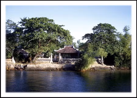 Một đền thờ nhỏ nằm bên bờ sông Hương, được chụp từ con tàu của hải quân Mỹ. Ngay phía trước ngôi đền, những đứa trẻ đang vẫy tay chào chúng tôi.