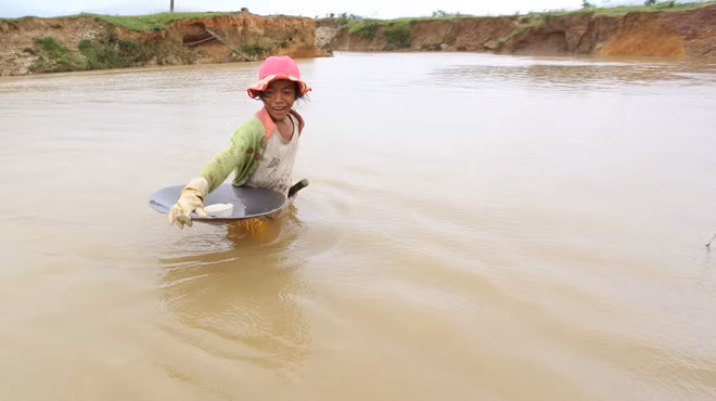 Em K Hạnh (10 tuổi) lội suối về nhà sau một ngày đi làm rẫy. Ảnh: Mai Vinh.