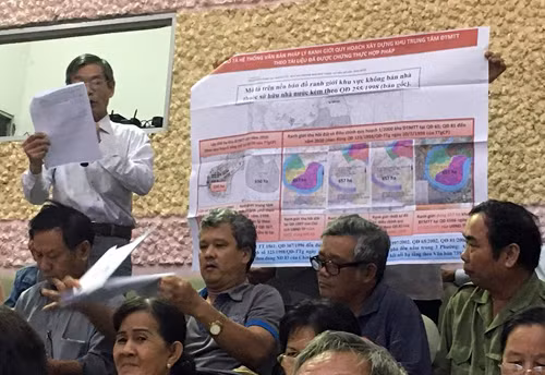 Người dân đưa ra tấm bản đồ quy hoạch Thủ Thiêm được Thủ tướng phê duyệt để đối chiếu với quy hoạch hiện tại. (Ảnh: H.L)