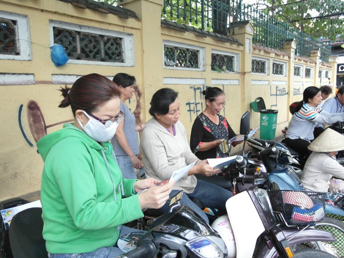 Các bà mẹ đang “giết thời gian” bằng những tờ báo trong lúc chờ con thi môn Tiếng Anh tại trường Marie Curie. Các bà mẹ đang “giết thời gian” bằng những tờ báo trong lúc chờ con thi môn Tiếng Anh tại trường Marie Curie.