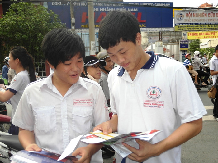 Hai nam sinh trường Nguyễn Bỉnh Khiêm vô tư xem quảng cáo các trường Đại học, Cao đẳng trên tờ rơi. Câu học sinh Quang Ngọc (phải) cho biết: “Đề thi tiếng Anh tương đối dễ. Em yên tâm đậu tốt nghiệp rồi”. Hai nam sinh trường Nguyễn Bỉnh Khiêm vô tư xem quảng cáo các trường Đại học, Cao đẳng trên tờ rơi. Câu học sinh Quang Ngọc (phải) cho biết: “Đề thi tiếng Anh tương đối dễ. Em yên tâm đậu tốt nghiệp rồi”.