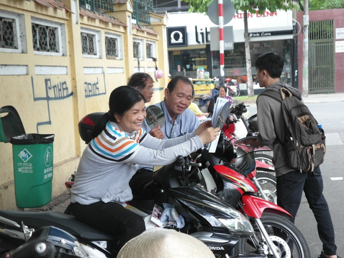 Trời nóng nực, tay phải cầm quạt giấy nhưng bà mẹ này khá vui vẻ và tự tin con mình làm bài tốt. Trời nóng nực, tay phải cầm quạt giấy nhưng bà mẹ này khá vui vẻ và tự tin con mình làm bài tốt.