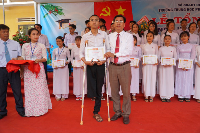 Hiển trong Lễ tổng kết cuối năm với tấm giấy khen đạt danh hiệu học sinh giỏi. Ảnh: P.L