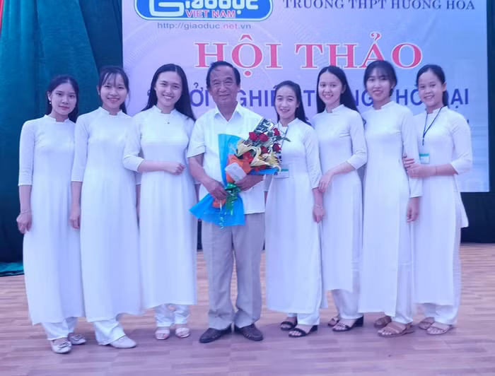 Giáo sư Nguyễn Lân Dũng chụp ảnh với nữ sinh của trường Hướng Hóa. (Ảnh: LC)