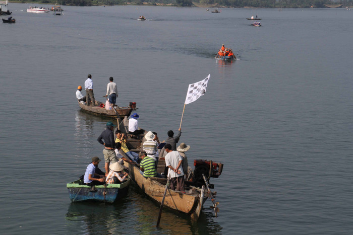 Một số ngư dân làm nghề chài lưới trên sông Cu Đê cũng ngưng công việc, dùng thuyền chở các cổ động viên để cổ vũ cho các đội đua...