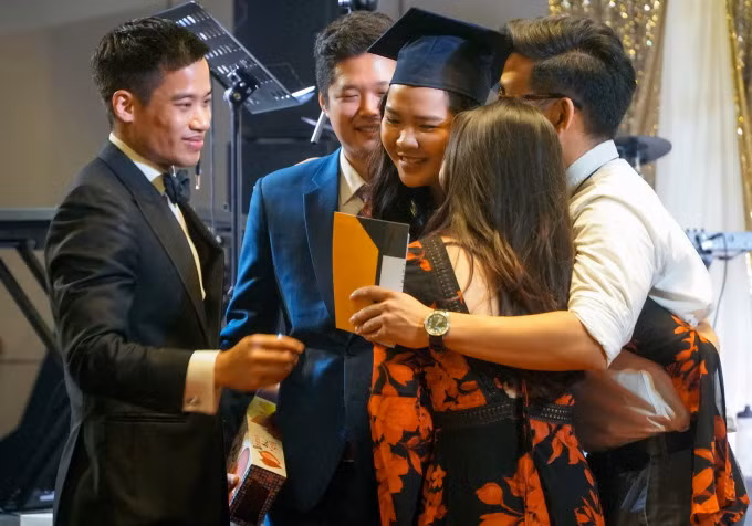 Ông Tommy Nguyễn - COO Point Avenue (áo đen) chúc mừng gia đình học sinh trúng tuyển đại học Mỹ. Ảnh: Point Avenue