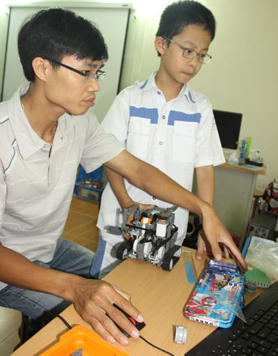 Thầy Cường chỉ dẫn học sinh cài đặt phần mềm để robot hoạt động. Thầy Cường chỉ dẫn học sinh cài đặt phần mềm để robot hoạt động.