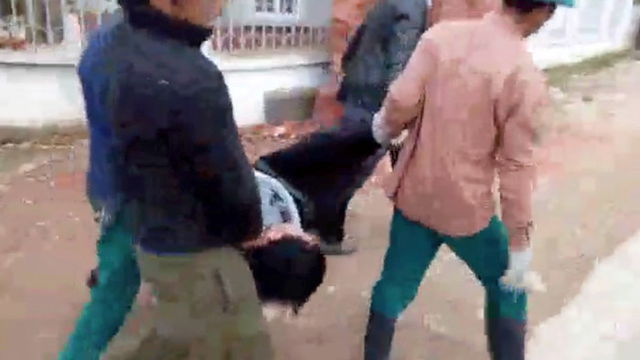 Anh Cao bị còng tay khiêng qua sân trường để đưa về trụ sở xã (ảnh cắt từ clip) Anh Cao bị còng tay khiêng qua sân trường để đưa về trụ sở xã (ảnh cắt từ clip)