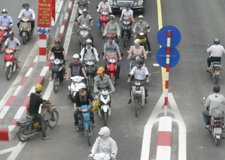 Rất nhiều trường hợp vi phạm luật khi tham gia lưu thông qua cầu vượt. Trong ảnh là một nam thanh niên đang tìm cách đi ngược chiều, cắt ngang dòng phương tiện đông đúc để lên phía bên kia cầu.