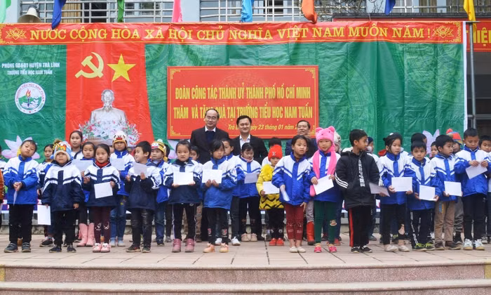 Bí thư Thành ủy Thành phố Hồ Chí Minh Nguyễn Thiện Nhân và lãnh đạo tỉnh Cao Bằng tặng quà học sinh trường Tiểu học Nam Tuấn (thị trấn Hùng Quốc, huyện Trà Lĩnh, tỉnh Cao Bằng). (Ảnh TP)