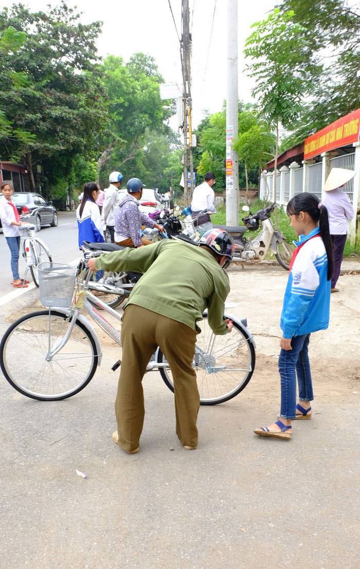 Một phụ huynh đang kiểm tra lại độ chắc, bền của chiếc xe con gái vừa được nhận. Sau khi kiểm tra, người cha rất hài lòng vì chiếc xe vừa chắc, vừa đẹp. (Ảnh: LC) Một phụ huynh đang kiểm tra lại độ chắc, bền của chiếc xe con gái vừa được nhận. Sau khi kiểm tra, người cha rất hài lòng vì chiếc xe vừa chắc, vừa đẹp. (Ảnh: LC)