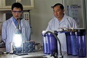 Tiến sỹ Nguyễn Chánh Khê (bìa phải) bên chiếc máy phát điện chạy bằng nước Tiến sỹ Nguyễn Chánh Khê (bìa phải) bên chiếc máy phát điện chạy bằng nước