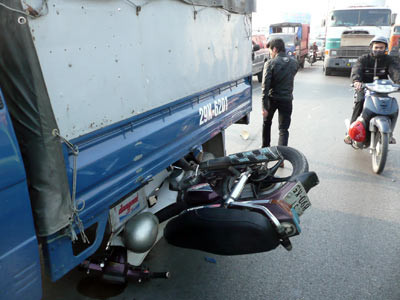 Chiều 13.12.2008, đang chạy trên quốc lộ 5 một xe tải chạy hướng Hải Phòng - Hà Nội bất ngờ nổ lốp lật ngang, húc vào giải phân cách. Xe máy đang xuôi theo hướng Hà Nội - Hải Phòng chạy sau bị ngã theo, cuốn vào gầm xe tải đi sau. Ảnh: VnExpress.