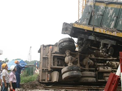 Khoảng 9 giờ sáng 13.8.2009, trên đoạn đường sắt nằm sát Quốc lộ 5 (thuộc địa phận Gia Lâm, Hà Nội) xảy ra vụ tai nạn giao thông giữa tàu hỏa chở hàng chạy hướng Hà Nội - Hải Phòng với một ô tô tải chở bùn. Tại hiện trường, chiếc ô tô tải biển kiểm soát 30K-4093 nằm giữa đường ray, cạnh đó là đầu tàu hỏa mang biển hiệu D4H454 sau khi kéo lê ô tô tải hơn 10m. Những người chứng kiến cho biết, khi xe tải đang lùi từ công trường ra thì tàu chở hàng đi tới nên đã dẫn đến tai nạn. Vụ tai nạn không gây thiệt hại về người. Ảnh: Tiền phong. Khoảng 9 giờ sáng 13.8.2009, trên đoạn đường sắt nằm sát Quốc lộ 5 (thuộc địa phận Gia Lâm, Hà Nội) xảy ra vụ tai nạn giao thông giữa tàu hỏa chở hàng chạy hướng Hà Nội - Hải Phòng với một ô tô tải chở bùn. Tại hiện trường, chiếc ô tô tải biển kiểm soát 30K-4093 nằm giữa đường ray, cạnh đó là đầu tàu hỏa mang biển hiệu D4H454 sau khi kéo lê ô tô tải hơn 10m. Những người chứng kiến cho biết, khi xe tải đang lùi từ công trường ra thì tàu chở hàng đi tới nên đã dẫn đến tai nạn. Vụ tai nạn không gây thiệt hại về người. Ảnh: Tiền phong.