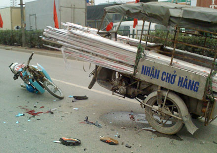 Vụ tai nạn xảy ra hồi 14h30 chiều 26.1.2010, trên Quốc lộ 5 đoạn ngã tư Châu Quỳ - Cổ Bi (Gia Lâm, Hà Nội). Một số nhân chứng có mặt tại hiện trường cho hay, vào khoảng thời gian trên, chiếc xe 3 bánh phía trước có gắn phù hiệu thương binh lưu thông hướng từ Hải Phòng về Hà Nội trên phần đường một chiều từ Hà Nội đi. Trên chiếc xe 3 bánh chở đầy các thanh khung nhôm dài ngoằng, vươn ra phía trước chừng hơn 1m và phía sau hơn 3m. Mặc dù đi ngược chiều, lái xe 3 bánh còn tiếp tục cho xe lượn ra phần đường dành riêng cho ô tô và xe máy ở tốc độ cao. Đến ngã tư Châu Quỳ - Cổ Bi, chiếc xe trên đã va chạm mạnh với một xe máy Dream chạy đúng chiều từ Hà Nội đi. Tai nạn đã khiến cho cả hai lái xe bất tỉnh. Ảnh: Dân trí.