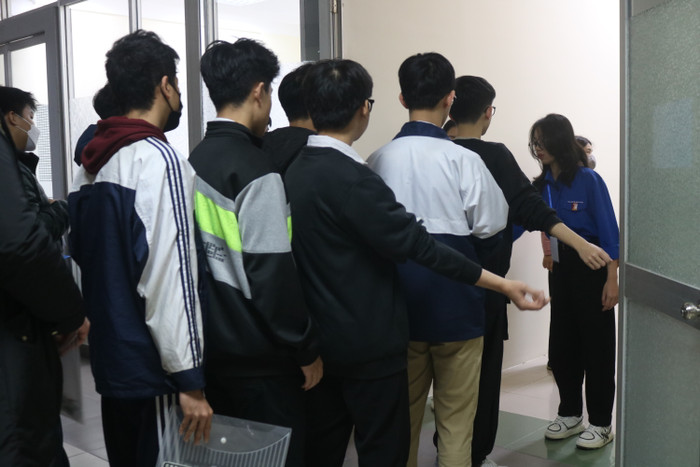 Trước khi bước vào phòng thi, thí sinh tiếp tục được kiểm tra bằng máy dò kim loại, thiết bị điện tử. Ảnh: Doãn Nhàn