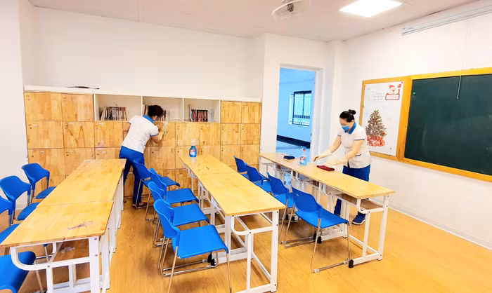 Bàn ghế, các tủ trong lớp học được nhân viên của trường lau chùi, sát khuẩn. Ảnh: NTCC
