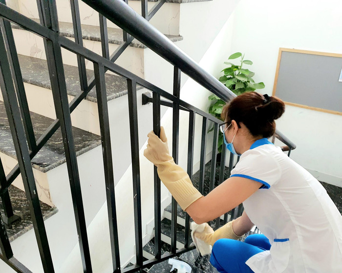 Các lan can cầu thang được lau chùi, sát khuẩn. Ảnh: NTCC