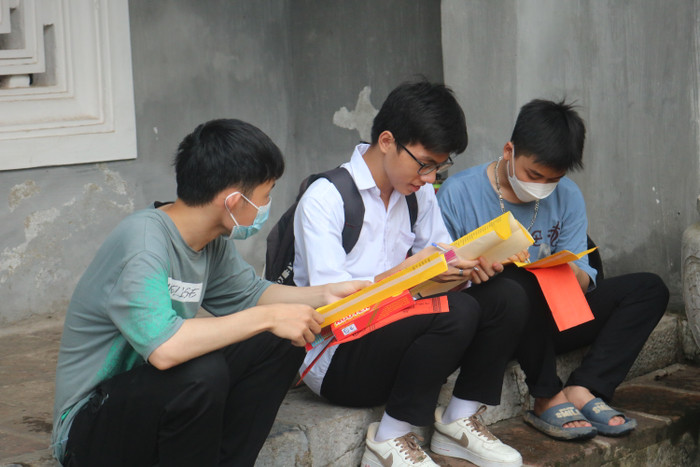 Nhóm học sinh Trường trung học phổ thông Hồng Thái, Đan Phượng chăm chú thảo luận, viết sớ cầu cho mình hoàn thành tốt kỳ thi tốt nghiệp trung học phổ thông.