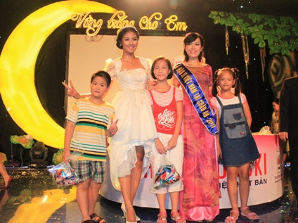 Ngọc Hân cùng Á hậu 2 người Việt tại Châu Âu 2011 Võ Hồng Quân chụp ảnh với các em nhỏ.