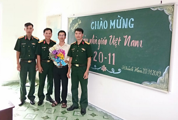 Thầy Bành Hữu Tình nhận đóa hoa tươi thắm từ các chiến sĩ Trường Sa. (Ảnh: H.T)