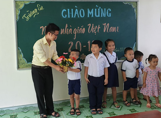 Các em học sinh dâng hoa tri ân thầy giáo. (Ảnh: H.T)