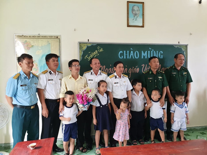 Phụ huynh, các chiến sĩ, người dân cùng thầy giáo và các em học sinh chụp hình lưu niệm. (Ảnh: H.T)