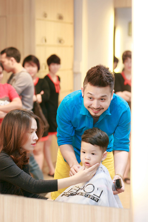 Cậu bé nghe lời mẹ ngồi yên để cắt tóc Cậu bé nghe lời mẹ ngồi yên để cắt tóc