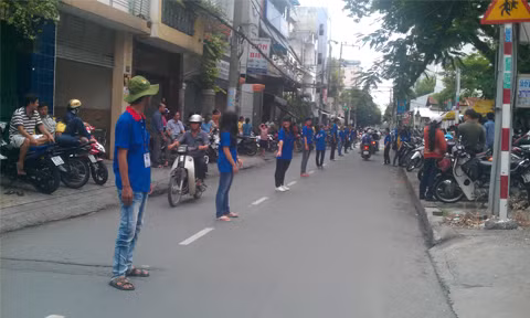 Sinh viên trường ĐH Kinh tế TP. HCM giữ trật tự giao thông trước trường Trần Văn Ơn cho kỳ thi vào lớp 6 trường chuyên Trần Đại Nghĩa. Ảnh: Nguyễn Thành Đạt.